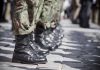 Soldiers in uniform and boots standing in formation.