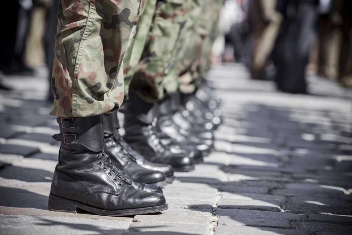 Soldiers in uniform and boots standing in formation.