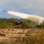 Military tank firing a missile in forest area.