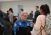 TSA agent checks passenger's documents at airport security.