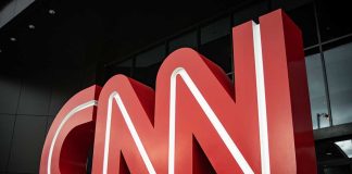 Large red CNN logo outside a building.