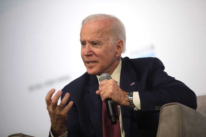 Man holding microphone and gesturing while speaking.