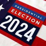 "Presidential Election 2024 sign on American flag background."