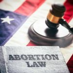 "Abortion law book, gavel, and American flag."