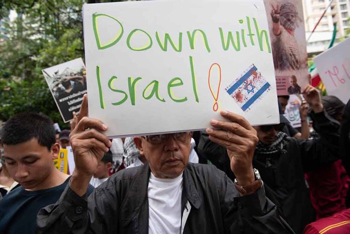 Person holding "Down with Israel" sign at protest.