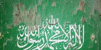 White Arabic script on weathered green background.