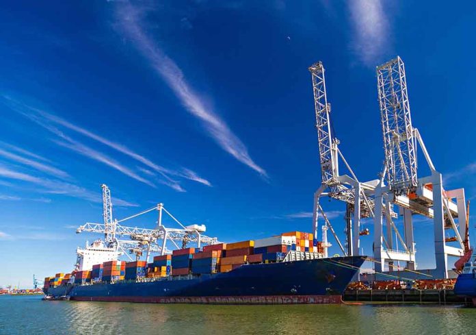 Cargo ship docked at port with cranes unloading.