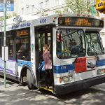 Person boarding clean air hybrid electric city bus.