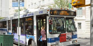 Person boarding clean air hybrid electric city bus.