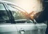 Person pointing gun at car window