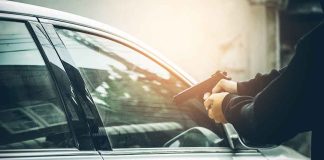 Person pointing gun at car window