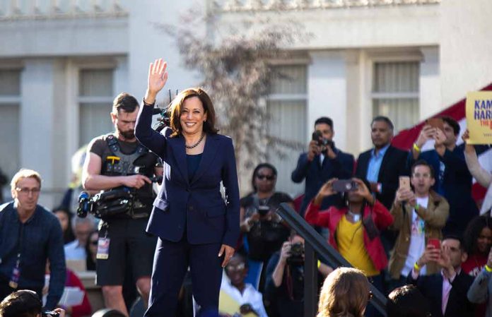 Woman in blue suit waving to a crowd.