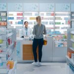 Customer talking to pharmacist at a bright pharmacy.