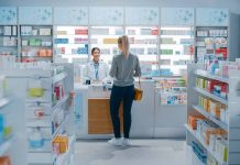 Customer talking to pharmacist at a bright pharmacy.