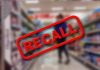 "Recall" stamp on blurred store aisle background.