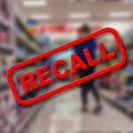 "Recall" stamp on blurred store aisle background.