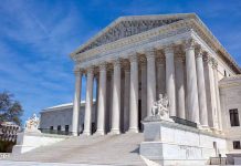 Supreme Court building with columns and statues.