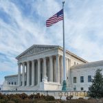 Supreme Court building with American flag flying.