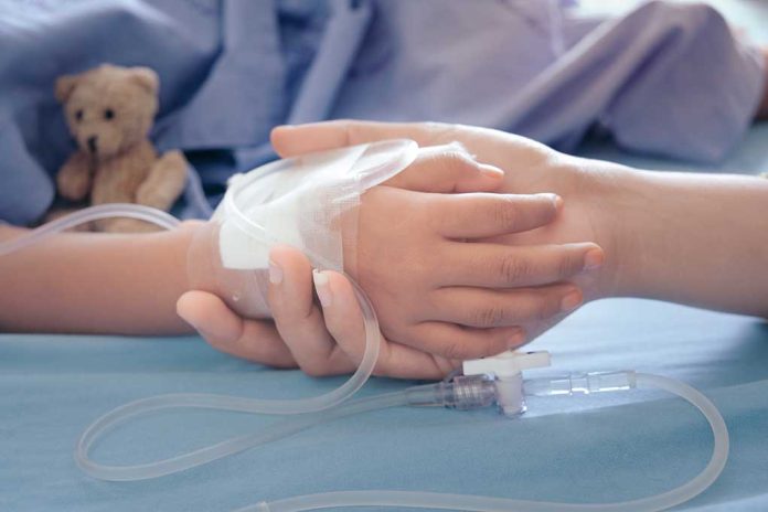 Child's hand with IV, held by adult.