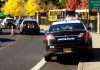 Police cars and school buses on a road.