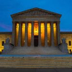 Illuminated courthouse building at dusk with columns