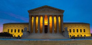 Illuminated courthouse building at dusk with columns