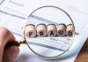 Magnifying glass showing FRAUD on an invoice