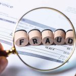 Magnifying glass showing FRAUD on an invoice