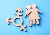 Wooden gender symbols on blue background