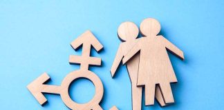 Wooden gender symbols on blue background