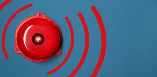 Red alarm bell on a blue background