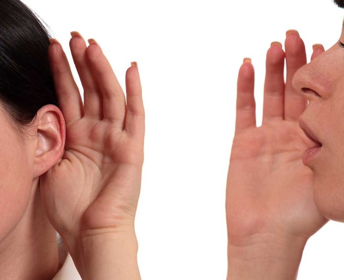 135276407 featured image Person whispering into another persons ear gesture