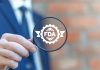 Person holding magnifying glass with FDA logo