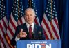 Man speaking at podium with American flags behind