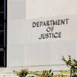 Department of Justice building exterior with window and plants