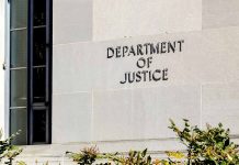 Department of Justice building exterior with window and plants