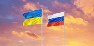 Ukrainian and Russian flags against a sunset background