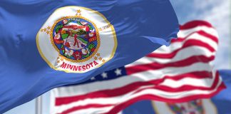 Minnesota state flag with American flag in background