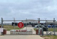 Chainlink fence with Restricted Area Stop No Photography sign