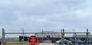 Chainlink fence with Restricted Area Stop No Photography sign