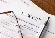 Lawsuit papers with glasses and pen on table