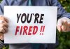 Person holding YOURE FIRED sign
