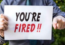 Person holding YOURE FIRED sign
