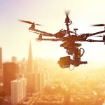 Drone flying over city at sunset time