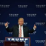 Person giving thumbs up at a political event