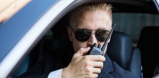 Man in suit using walkie-talkie in car
