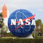 Blue NASA globe with rocket in background