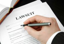 Filling out lawsuit form with pen