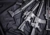 Assault rifles arranged on a black fabric background