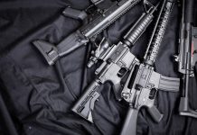 Assault rifles arranged on a black fabric background
